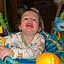 Elijah is registered to the contest to win money with this photo: child, toddler, baby, smiling, laughing, face, teeth, onesie, patterned_clothing, exersaucer, toy, colorful, indoor, home, playtime, seat, closeup, happy, blue, orange