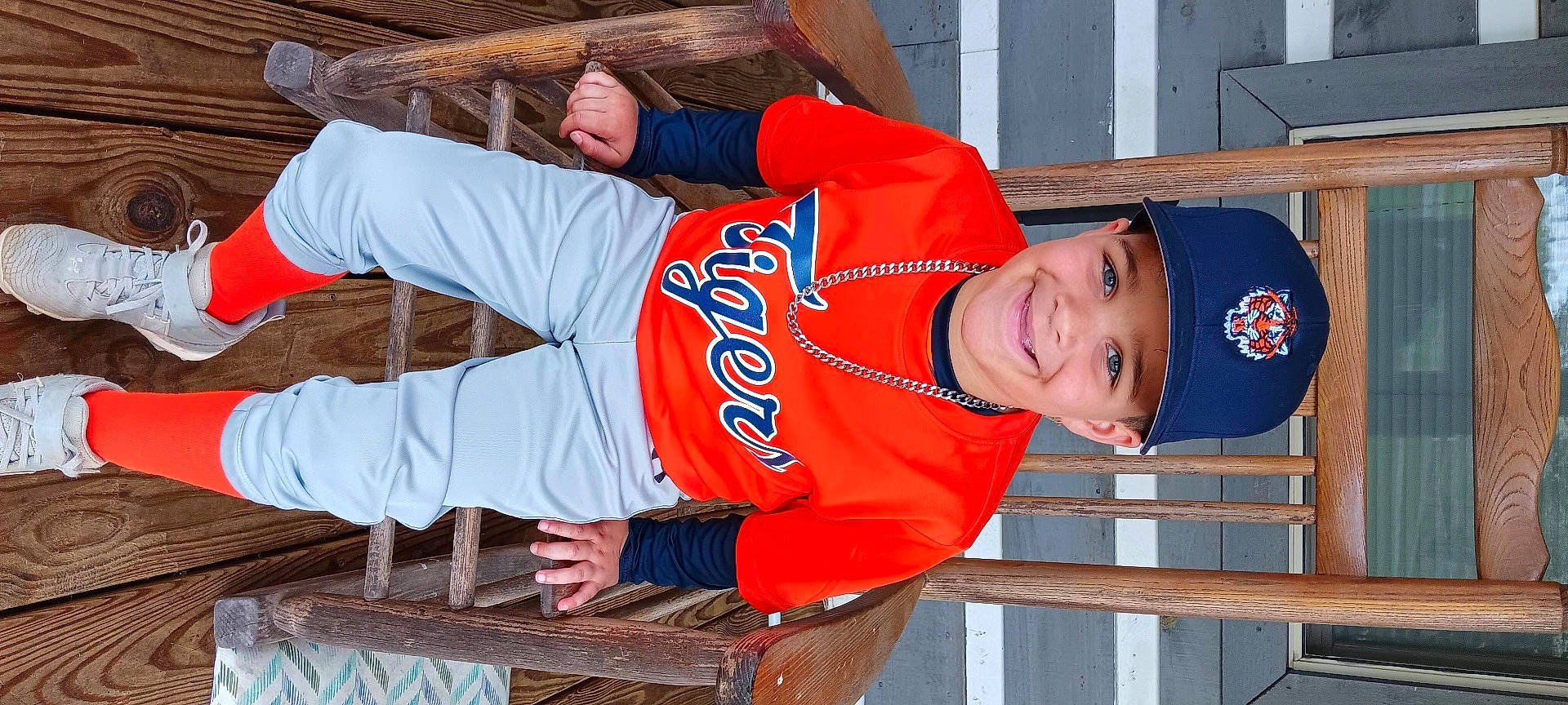 Kason is registered to the contest to win money with this photo: baseballcap, boy, cap, child, clothing, face, footwear, furniture, hat, head, hosiery, male, pants, person, photography, plywood, portrait, sock, t_shirt, wood