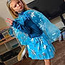 Kensley is registered to the contest to win money with this photo: child, girl, costume, tiara, cape, snowflake, blue, pose, peace_sign, pout, carpet, television, bookshelf, dvd, indoor, living_room, clothing, footwear, smile, playful