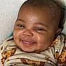 Prince is registered to the contest to win money with this photo: baby, smile, child, infant, face, clothing, cute, portrait, happy, lying_down, young_child, animal_print, tiger, lion, skin, person, closeup, indoors, head, expression