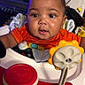 Prince joined the competition — help win amazing prizes! baby, child, infant, face, eyes, drool, orange_shirt, toy, flower_toy, activity_center, indoor, curious, cute, skin, expression, sitting, closeup, head, play, young
