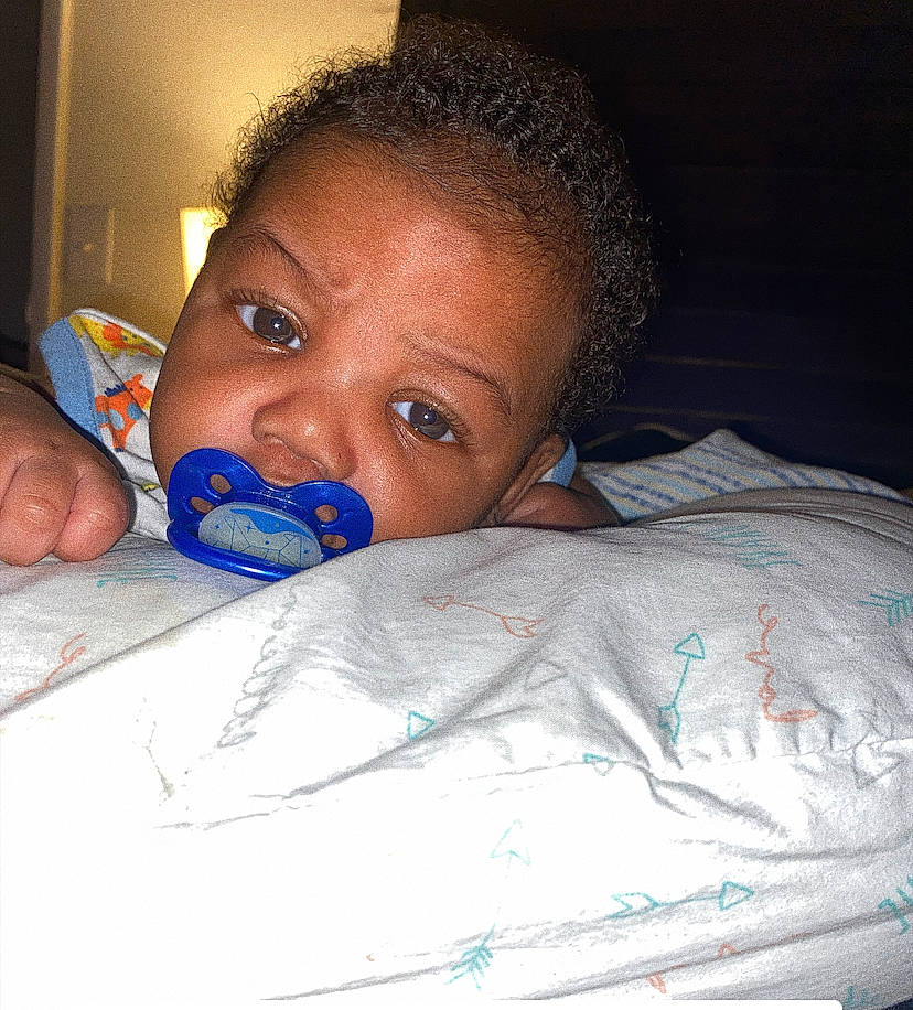 Juelz is registered to the contest to win money with this photo: cheek, child, ear, eyebrow, eyelash, finger, forehead, hand, happy, human_body, iris, jaw, linens, lip, mouth, nail, nose, person, room, skin