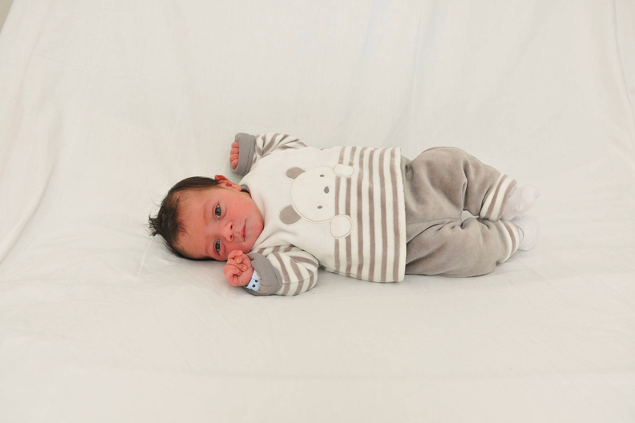 Mayron participe au concours pour gagner de l'argent avec cette photo : arm, baby, baby_toddler_clothing, child, collar, comfort, elbow, fashion_accessory, flooring, human_body, linens, monochrome, neck, pattern, person, portrait_photography, sitting, sleeve, t_shirt, toddler