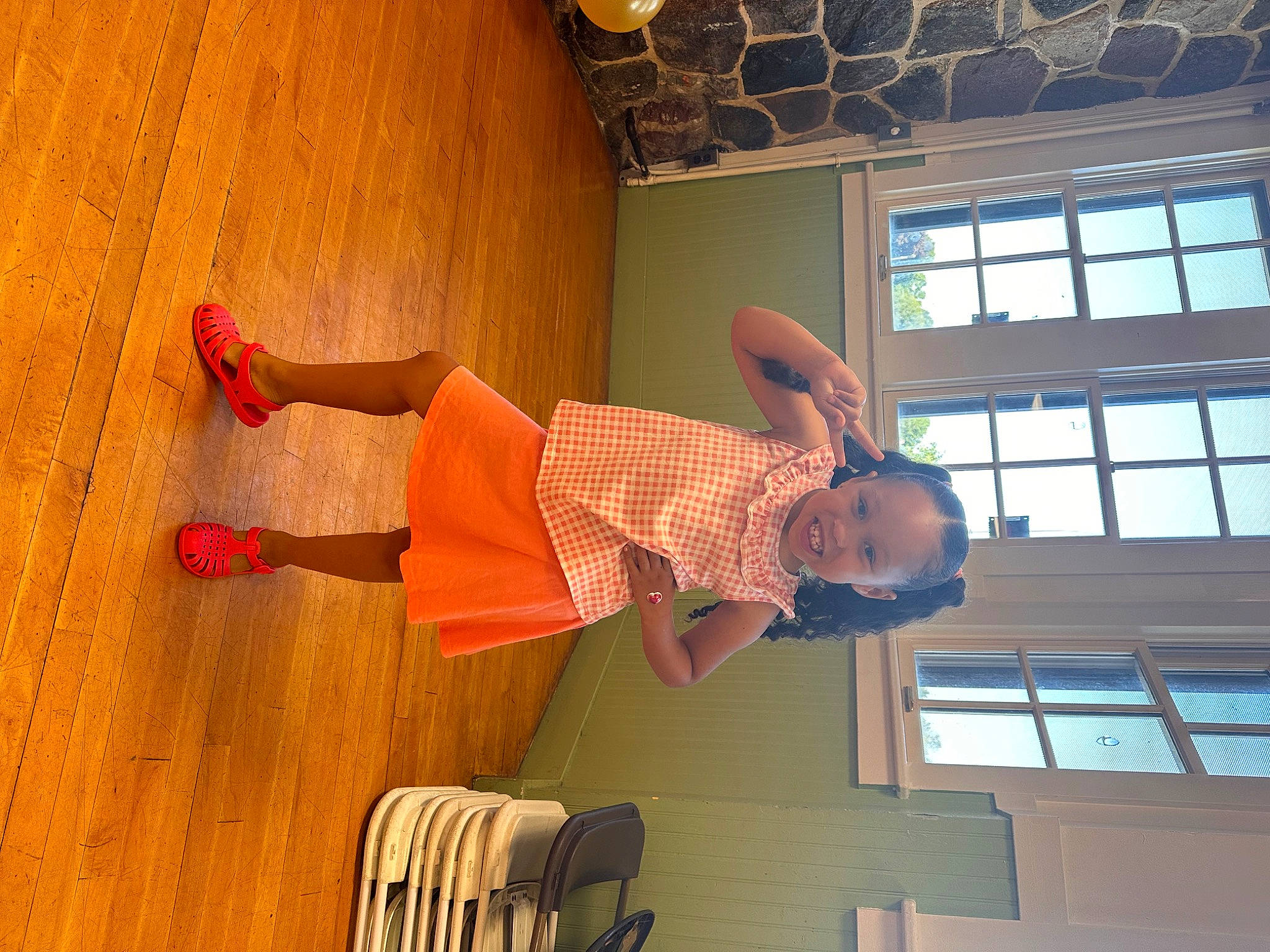 Nylah is registered to the contest to win money with this photo: balance, ceiling, chair, elbow, flooring, fun, happy, hardwood, human_leg, joy, knee, leisure, person, room, table, thigh, toddler, varnish, window, wood