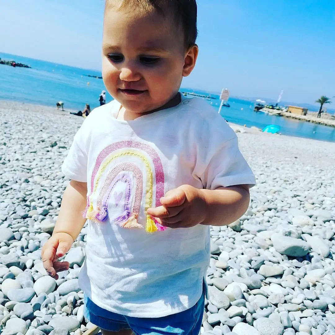 Bianca a rejoint le concours — aidez-le/la à gagner de superbes lots ! azure, beach, blue, face, hairstyle, happy, light, natural_environment, organ, people_in_nature, people_on_beach, person, photograph, product, shirt, sky, sleeve, standing, t_shirt, travel
