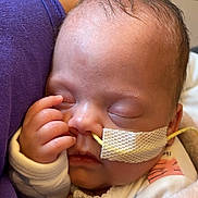 Zemira is registered to the contest to win money with this photo: baby, blanket, closed_eyes, cozy, cute, face, feeding_tube, hand, hospital, indoors, infant, medical, newborn, person, purple_clothing, resting, skin, sleeping, soft, tissue_tape