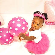 Ava joined the competition — help win amazing prizes! toddler, child, balloon, pink_tutu, tiara, polka_dots, birthday, celebration, indoor, cute, playing, smiling, happy, white_background, party, dress, sitting, portrait, african_american, toy