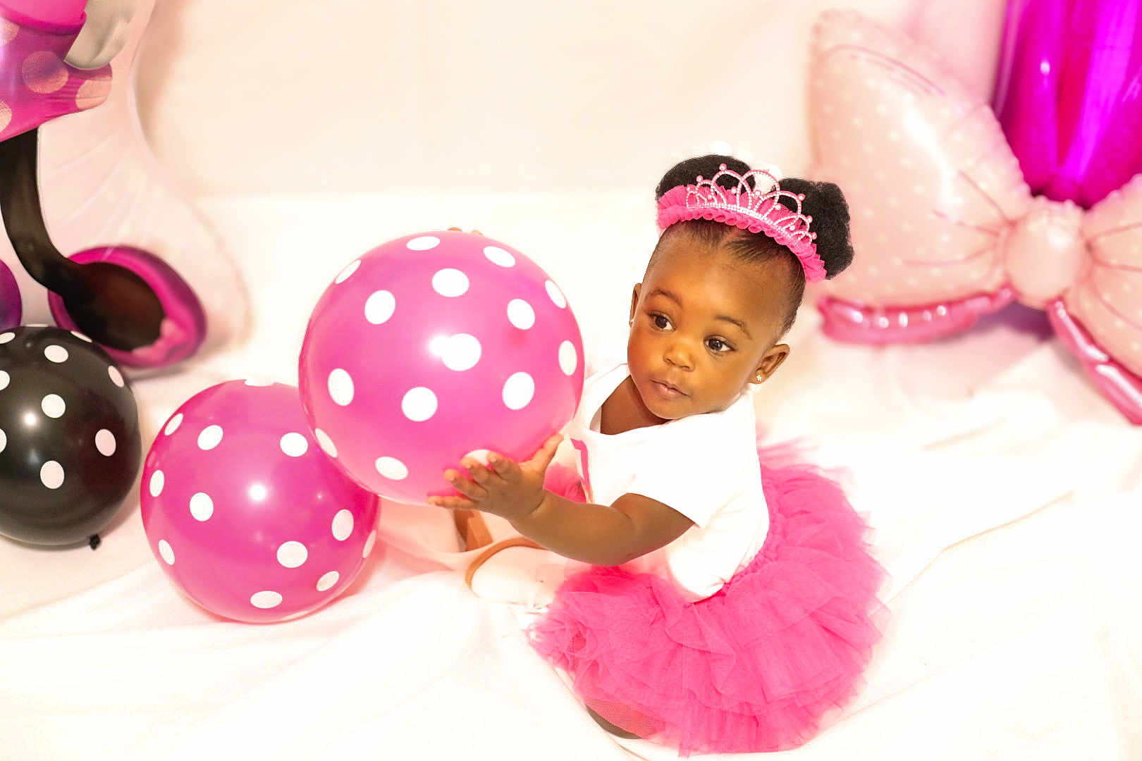Ava joined the competition — help win amazing prizes! toddler, child, balloon, pink_tutu, tiara, polka_dots, birthday, celebration, indoor, cute, playing, smiling, happy, white_background, party, dress, sitting, portrait, african_american, toy