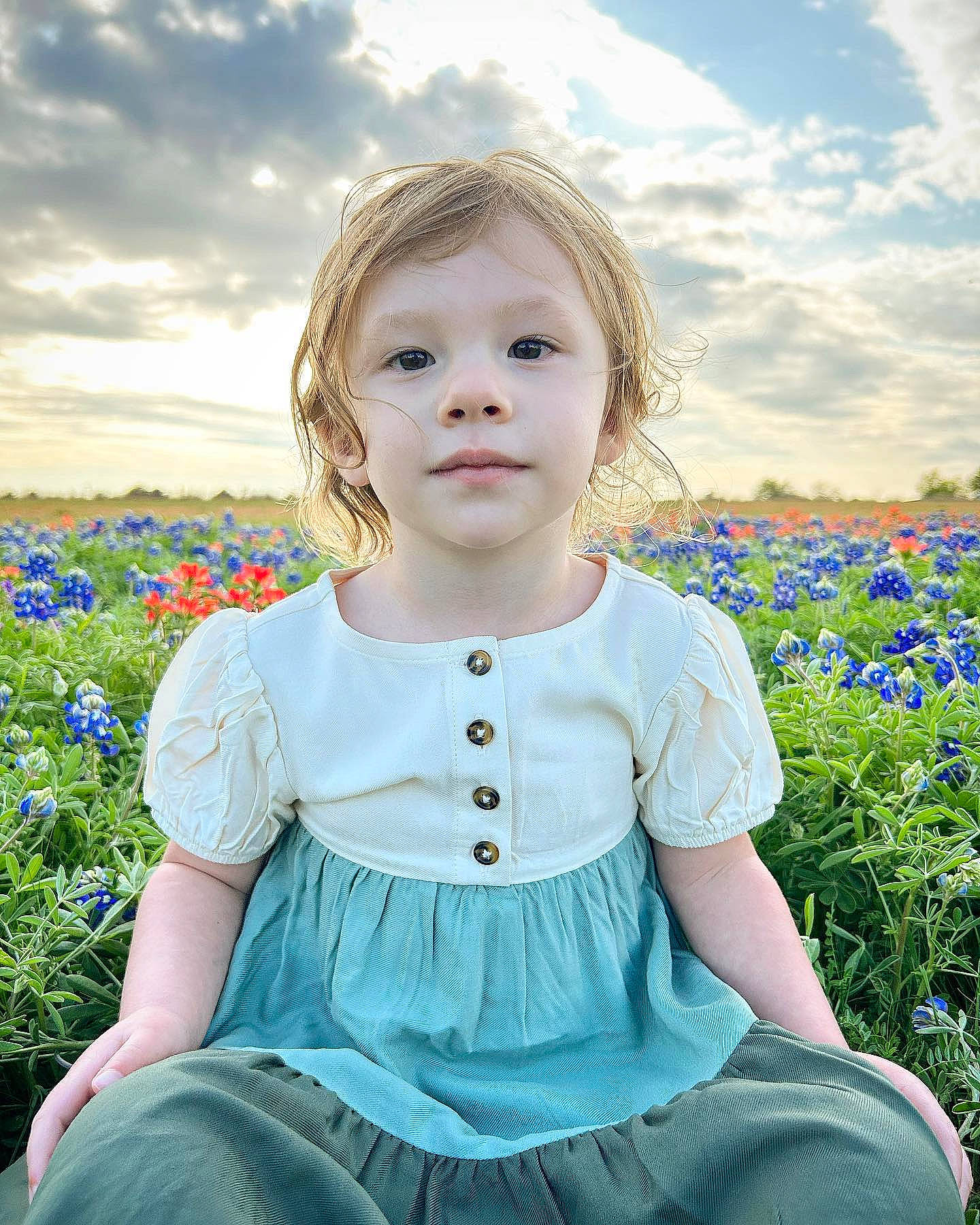 Zeniah is registered to the contest to win money with this photo: baby_toddler_clothing, beauty, blue, child, cloud, flash_photography, flower, grass, grassland, happy, iris, meadow, people_in_nature, person, plant, skin, sky, sleeve, standing, sunlight