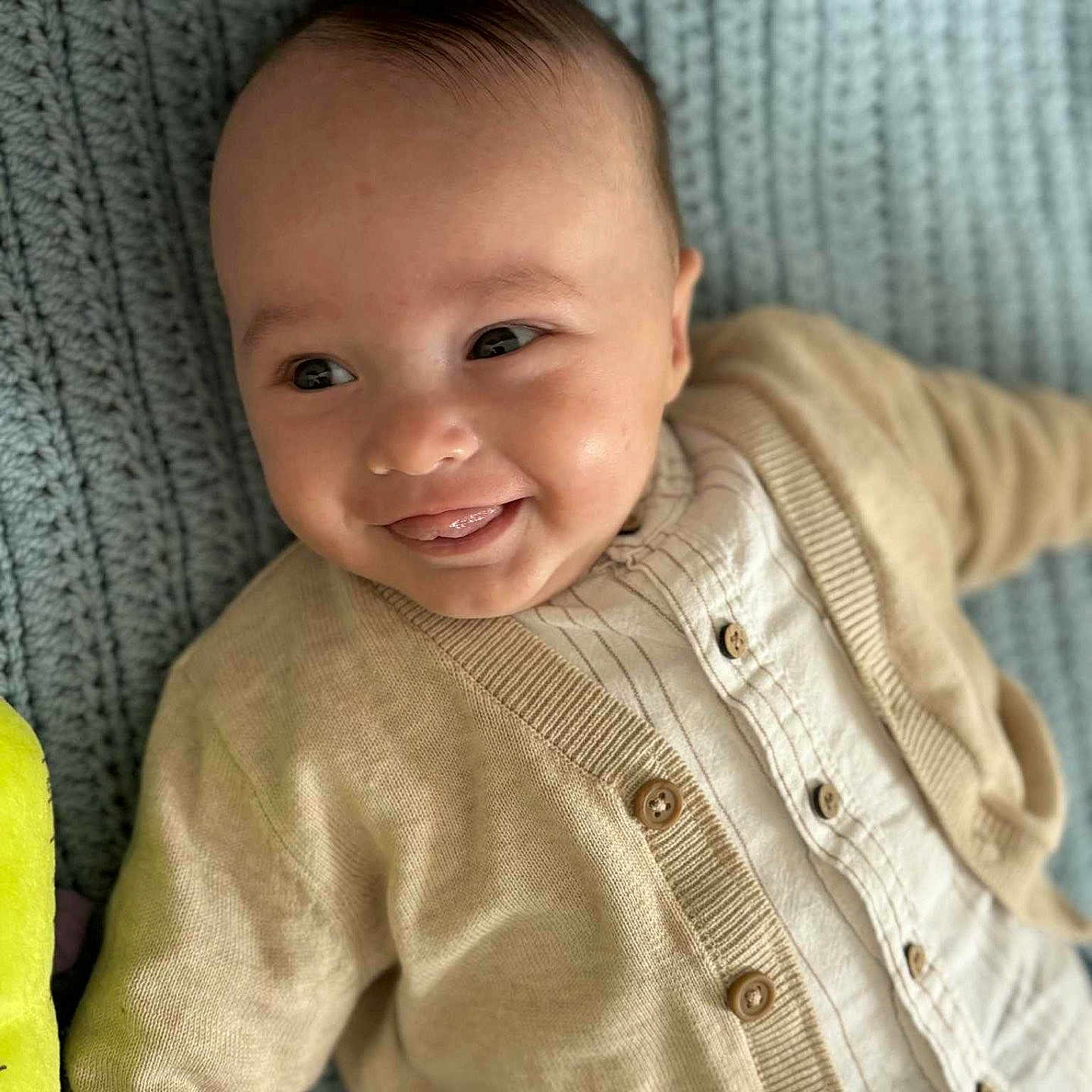 Louis participe au concours pour gagner de l'argent avec cette photo : baby, button_up_shirt, cardigan, child, closeup, clothing, cute, face, happy, indoors, infant, knit_blanket, lying_down, playful, portrait, smiling, soft_lighting, texture, tongue_out, young_child