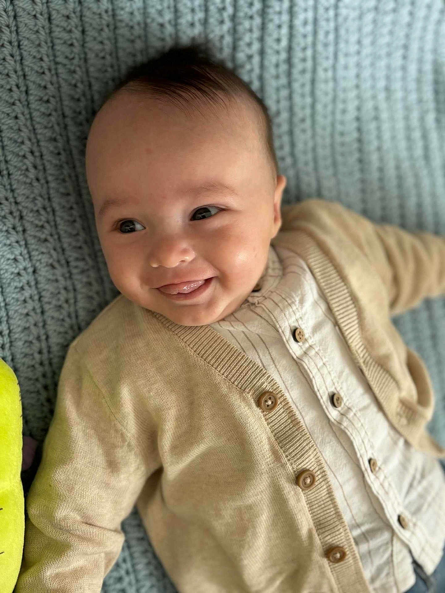 Louis participe au concours pour gagner de l'argent avec cette photo : baby, button_up_shirt, cardigan, child, closeup, clothing, cute, face, happy, indoors, infant, knit_blanket, lying_down, playful, portrait, smiling, soft_lighting, texture, tongue_out, young_child