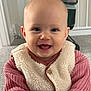 baby, child, smiling, face, indoor, clothing, vest, sweater, carpet, person, cute, happy, portrait, young_child, infant, head, eyes, mouth, skin, furniture