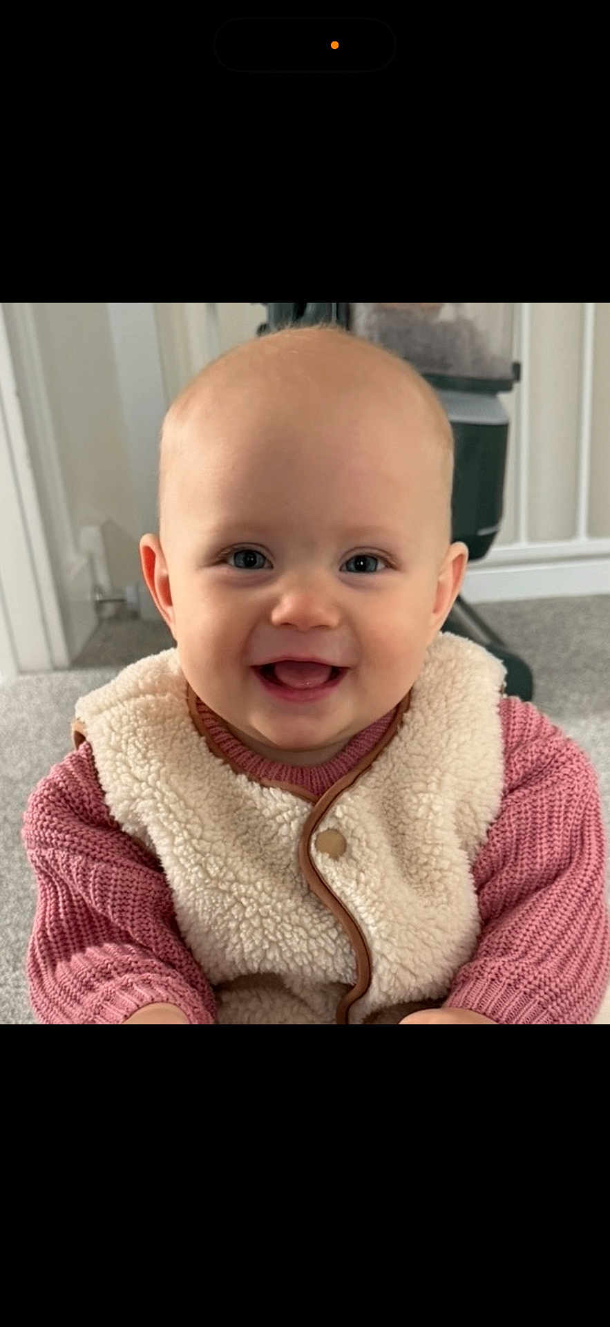 Ayla joined the competition — help win amazing prizes! baby, child, smiling, face, indoor, clothing, vest, sweater, carpet, person, cute, happy, portrait, young_child, infant, head, eyes, mouth, skin, furniture