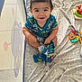 Jaxen joined the competition — help win amazing prizes! baby, blanket, blue_shirt, car_prints, child, clothing, colorful, cute, face, happy, holding, indoor, infant, patterned, playpen, sitting, smiling, toddler, toy, young_child
