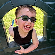Brantley joined the competition — help win amazing prizes! child, boy, sunglasses, playground, green, black_shirt, smiling, happy, outdoor, grass, sunlight, face, arm, play, toy, fun, summer, casual, person, window
