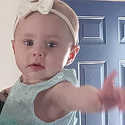 Layla joined the competition — help win amazing prizes! baby, child, headband, dress, mint_color, reaching, indoor, door, light_fixture, curious, person, cute, young_child, portrait, closeup, infant, toddler, baby_girl, fashion, accessory