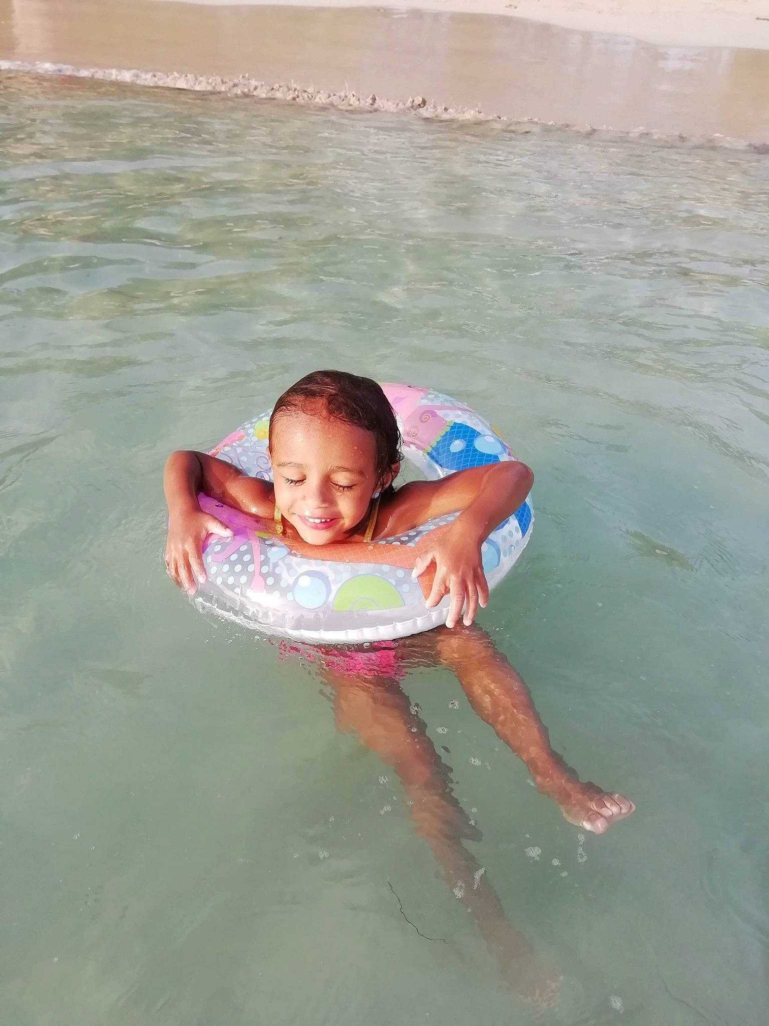 Jayana a rejoint le concours — aidez-le/la à gagner de superbes lots ! bathing, beach, body_of_water, child, fun, happy, holiday, joy, leisure, ocean, people_on_beach, person, personal_protective_equipment, recreation, sand, shorts, smile, summer, toddler, water