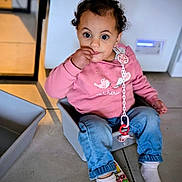 Lyah participe au concours pour gagner de l'argent avec cette photo : baby, casual_clothing, child, childhood, curly_hair, cute, expression, finger_in_mouth, floor_tiles, indoor, jeans, pacifier, pink_sweatshirt, plastic_container, playing, sitting, socks, toddler, toy_phone, young