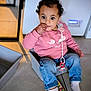 baby, casual_clothing, child, childhood, curly_hair, cute, expression, finger_in_mouth, floor_tiles, indoor, jeans, pacifier, pink_sweatshirt, plastic_container, playing, sitting, socks, toddler, toy_phone, young