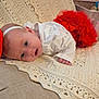 baby, infant, red_bow, red_skirt, white_shirt, blanket, crochet, chair, furniture, indoors, cute, portrait, face, headband, lying_down, skin, hand, foot, expression, curious