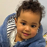 Gloria participe au concours pour gagner de l'argent avec cette photo : toddler, child, curly_hair, blue_jacket, smile, face, portrait, indoor, cute, young_child, clothing, warm, cozy, closeup, baby, person, head_and_shoulders, curiosity, soft_lighting, casual