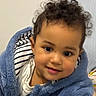 toddler, child, curly_hair, blue_jacket, smile, face, portrait, indoor, cute, young_child, clothing, warm, cozy, closeup, baby, person, head_and_shoulders, curiosity, soft_lighting, casual