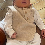 Soan Kayden a rejoint le concours — aidez-le/la à gagner de superbes lots ! newborn, baby, sleeping, infant, clothing, white_pants, beige_vest, person, hand, floor, tile_floor, chair, wooden_chair, indoor, cozy, resting, peaceful, soft_lighting, portrait, closeup