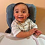 baby, cheeks, child, eyes, feeding_chair, hair, hands, happy, highchair, indoor, necklace, person, portrait, skin, smile, striped_shirt, teeth, toddler, tray, wall