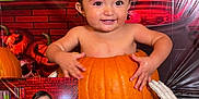 Mateo is registered to the contest to win money with this photo: baby, celebration, child, costume, cute, decoration, face, floor, halloween, happy, holiday, indoor, milestone, orange, portrait, pumpkin, sign, skeleton_hand, smiling, wet_hair