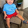Mateo joined the competition — help win amazing prizes! child, toddler, smiling, sitting, chair, blue_tshirt, red_shorts, sandals, indoor, plant, flooring, wood_floor, television, happy, person, home, furniture, face, cute, casual_clothing