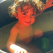 Mateo joined the competition — help win amazing prizes! child, toddler, curly_hair, bathtub, water, sunlight, smile, hand, wet_hair, indoor, basin, skin, cute, playful, bath_time, glowing, portrait, young_child, happy, curious