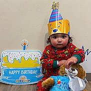 Mateo joined the competition — help win amazing prizes! toddler, child, party_hat, birthday, teddy_bear, plush_toy, red_pajamas, floor, wooden_floor, celebration, sign, indoor, cute, sitting, toy_clothing, smiling_face, wall, decor, festive, young_child