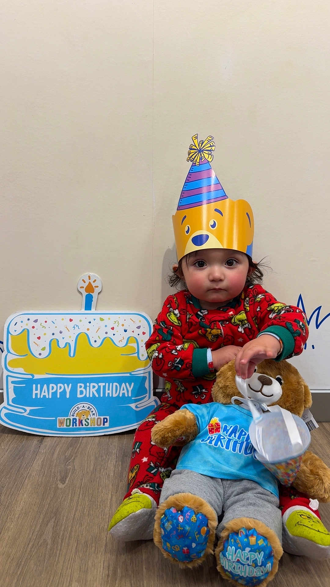 Mateo joined the competition — help win amazing prizes! toddler, child, party_hat, birthday, teddy_bear, plush_toy, red_pajamas, floor, wooden_floor, celebration, sign, indoor, cute, sitting, toy_clothing, smiling_face, wall, decor, festive, young_child