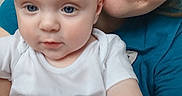Daxtin is registered to the contest to win money with this photo: baby, child, woman, person, face, smile, blue_eyes, white_shirt, patterned_pants, indoor, closeup, portrait, holding, cute, family, parent, infant, skin, head, hair