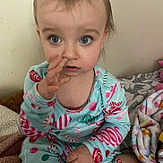 Gianna is registered to the contest to win money with this photo: toddler, child, blue_eyes, pajamas, indoor, blanket, hand, face, curious, sitting, cozy, soft_fabric, home, wall, expression, person, clothing, cute, young_child, portrait