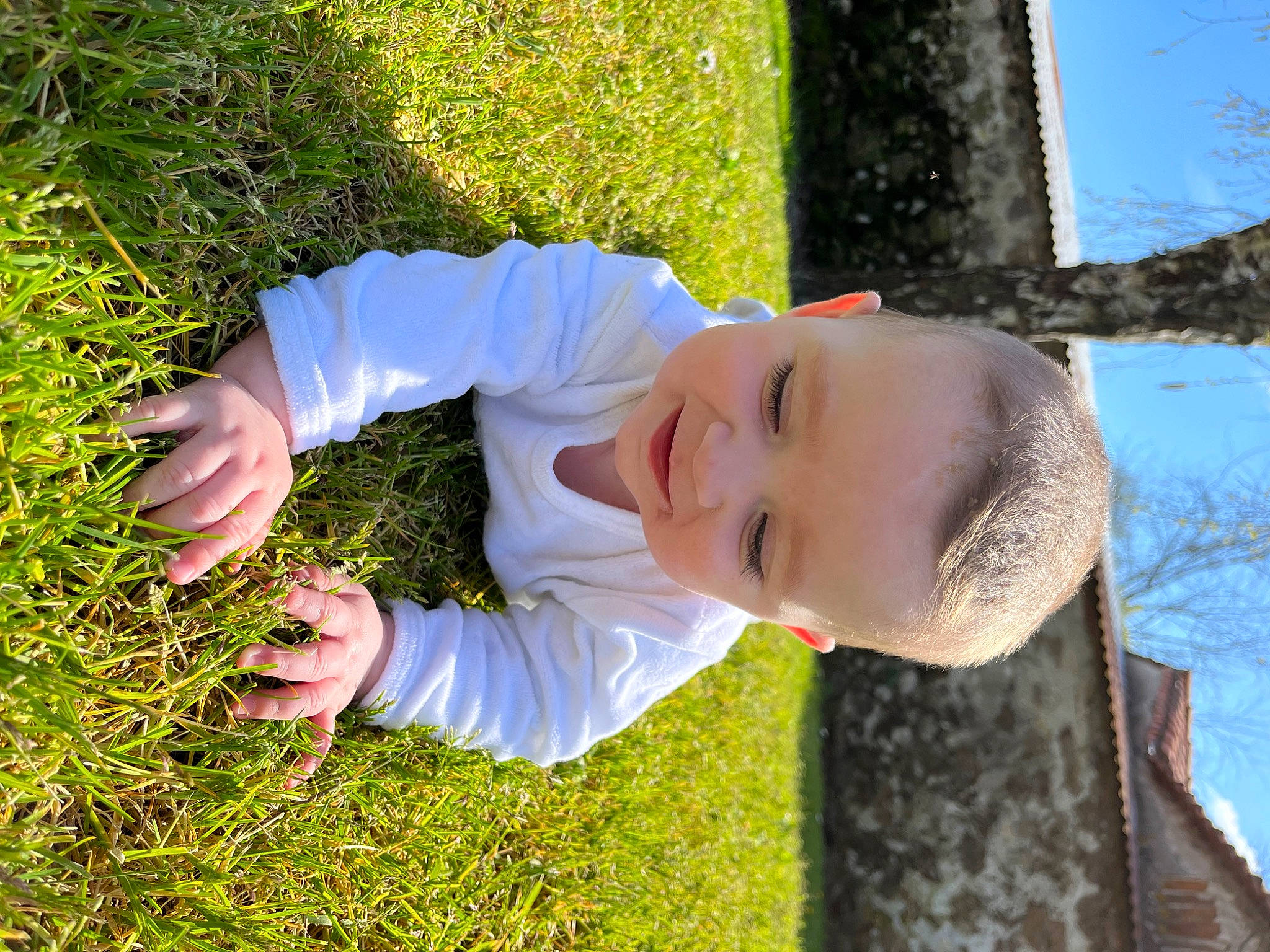 Mélia participe au concours pour gagner de l'argent avec cette photo : baby_toddler_clothing, child, finger, fun, gesture, grass, grass_family, groundcover, happy, lawn, leaf, people_in_nature, person, plant, sky, smile, sunlight, thumb, toddler, tree
