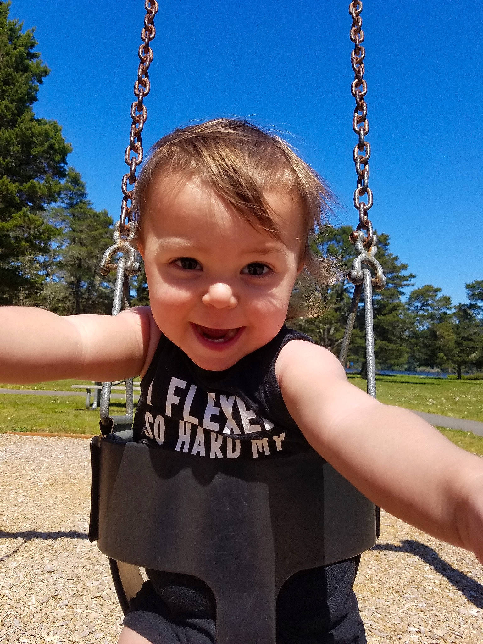 Akira joined the competition — help win amazing prizes! child, city, outdoor_play_equipment, person, playground, public_space, recreation, smile, summer, swing, toddler, tree, vacation