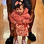 toddler, child, pink_jacket, dress, bow_headband, shoes, tattoos, adult_hands, floor, indoor, smile, happy, standing, supporting, person, clothing, footwear, cute, baby, portrait
