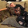 animal, blanket, boy, casual_clothing, comfort, couch, cute, dog, domestic, friendship, hat, human, indoor, living_room, nap, pet, pillow, relaxing, resting, sleeping