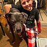 Kuda is registered to the contest to win money with this photo: boy, canine, casual_clothing, child, companion, dog, domestic_animal, floor, furniture, happy, holiday_theme, home, indoor, kneeling, pajamas, pet, plant, red_cast, smiling, wooden_floor