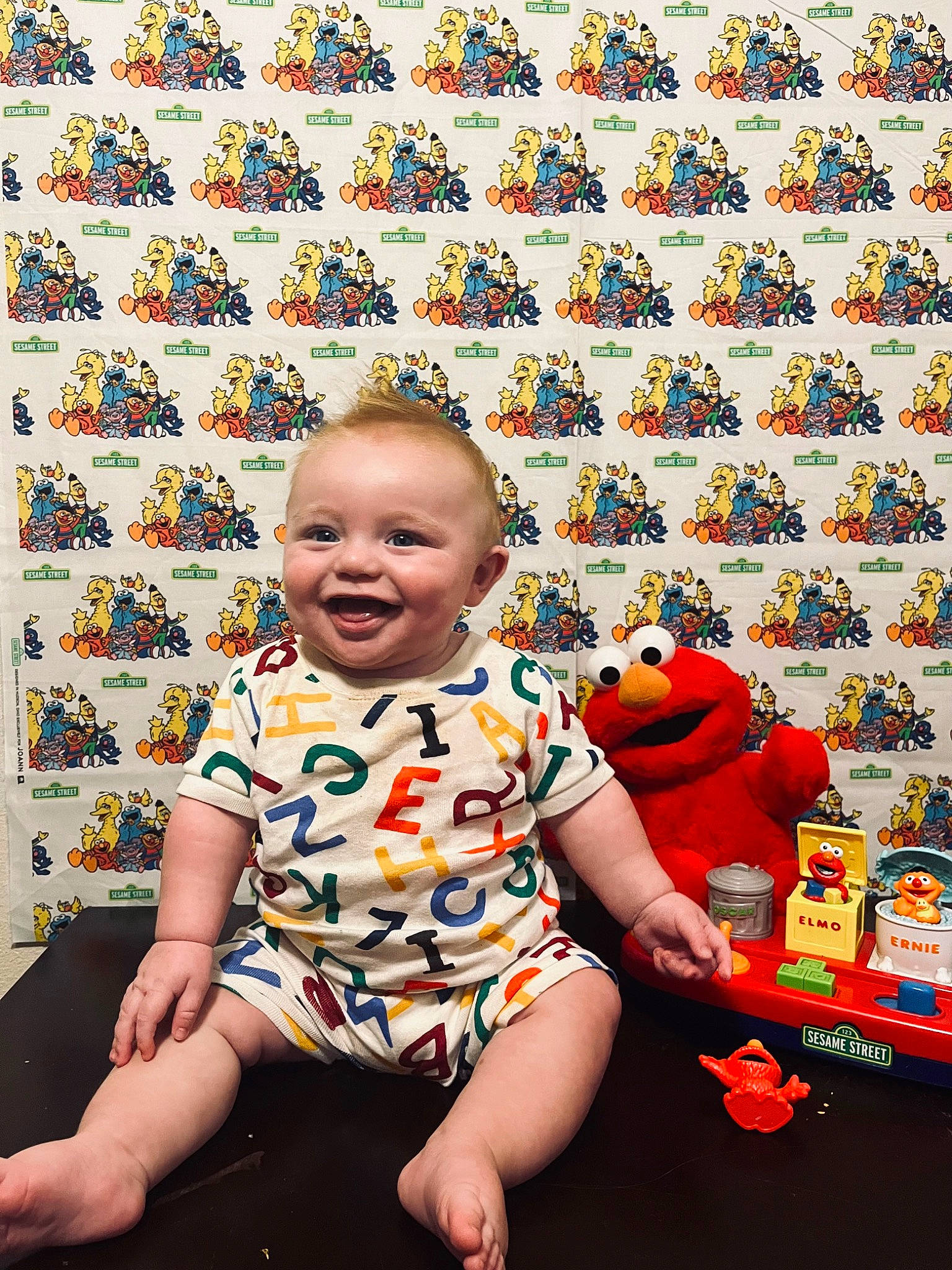 Indigo is registered to the contest to win money with this photo: art, baby, baby_laughing, baby_toddler_clothing, child, flooring, fun, happy, joy, leisure, pattern, people_in_nature, person, photograph, plant, shorts, sitting, smile, snapshot, sunglasses