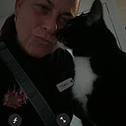 Luna is registered to the contest to win money with this photo: person, cat, black_and_white_cat, indoor, selfie, affection, close_up, dark_lighting, facial_expression, camera_interface, technology, pet, animal, human, love, interaction, portrait, domestic, feline, cute