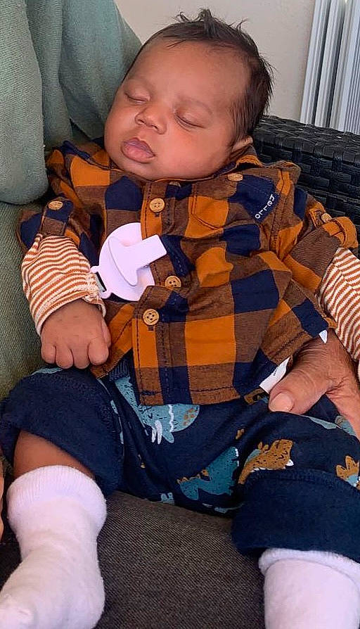 Gabriel participe au concours pour gagner de l'argent avec cette photo : baby, baby_products, baby_toddler_clothing, brown, cheek, child, comfort, curtain, finger, lap, leg, pattern, person, plaid, sitting, skin, sleeve, sock, thigh, toddler