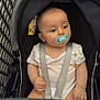 baby, pacifier, stroller, shopping_cart, child, infant, seatbelt, indoor, tiled_floor, person, cute, clothing, head, face, safety, young_child, shopping, retail, cart, curious