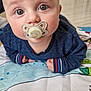 baby, pacifier, blue_sweater, play_mat, indoor, curious, wide_eyes, infant, child, cute, portrait, close_up, floor, striped_cuffs, lying_down, head_up, skin, person, young_child, cozy