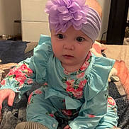 Sofia joined the competition — help win amazing prizes! baby, child, headband, flower, floral_clothing, sitting, blanket, indoor, cute, curious, sock, portrait, infant, person, blue_clothing, pink_flower, soft_lighting, furniture, cabinet, home