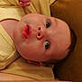 baby, infant, face, eyes, mouth, skin, yellow_clothing, lying_down, portrait, closeup, expression, soft_texture, child, newborn, cute, indoors, warm_colors, human, head, innocence