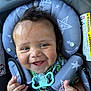 baby, smiling, car_seat, pacifier, star_pattern, child, happy, infant, clothing, seatbelt, face, hand, cute, young_child, safety, indoors, person, closeup, expression, red_bracelet