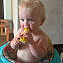 Ryker is registered to the contest to win money with this photo: baby, child, corn_on_the_cob, eating, walker, blond_hair, blue_eyes, indoor, cute, chubby, focused, sitting, hand, food, mouth, skin, person, young_child, feeding, colorful