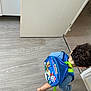 backpack, barefoot, blue, casual, child, clothing, curly, curly_hair, door, floor, indoor, kid, motion, paw_patrol, person, playful, room, toy, walking, young